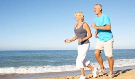 older couple running on the beach